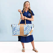 woman holding monogrammed charleston weekender in blue botanicals