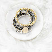 multi metallic bracelet set sitting on marble