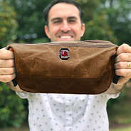 Man holding Gamecocks SP23 Waxed Canvas Dopp Kit