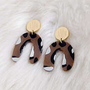 Monogrammed Leopard Arch Earrings on furry rug