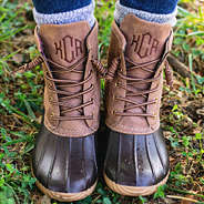 brown monogrammed duck boots in grass