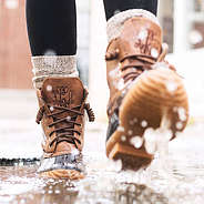 brown monogrammed duck boots water puddle