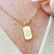 close up of monogramed tag on necklace