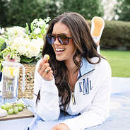 girl wearing monogrammed quarter zip sweatshirt in white blue seersucker on picnic blanket