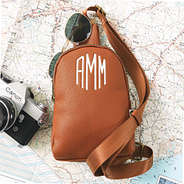 brown sling bag on top of map
