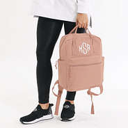 holding monogrammed blush canvas backpack