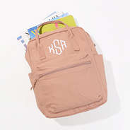monogrammed canvas blush backpack with books and magazines inside