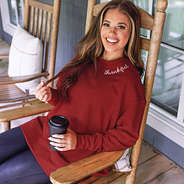 burgundy thankful sweatshirt on peyton in rocking chair