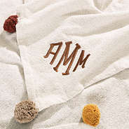 up close details of monogrammed pom pom blanket fabric