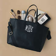 Items spilling out of Carry On Travel Tote in black