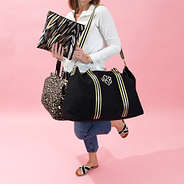 black and gold travel bag set with pink background