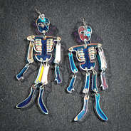 skeleton earrings on dark background