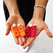 red and orange touchdown earrings in hand