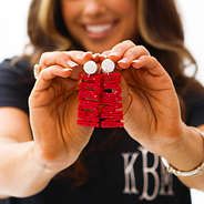 red touchdown earrings in hand