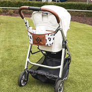 black sassy spots stroller caddy with stroller on grass