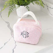 pink seersucker makeup bag on bathroom counter