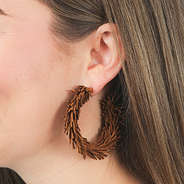 brown fringe hoop earrings in ears