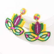 mardi gras earrings propped on white white background