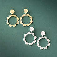 silver and gold scallop earrings on green paper