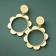 gold scallop earrings on green paper