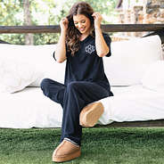 girl wearing black monogrammed pajama set with moccasins