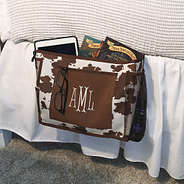 bedside cowhide monogrammed caddy on bed