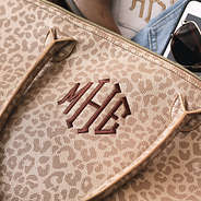 upclose of monogrammed gold leopard metallic weekend bag