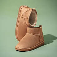 sherpa ankle booties on green background