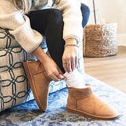 sherpa ankle booties with socks being pulled on