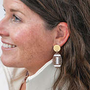 monogrammed football earrings in ears