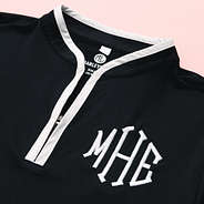 close up of monogrammed quarter zip black dress