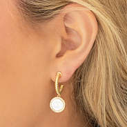 silver and gold cable hoop earrings in ear