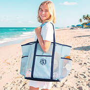 girl carrying monogrammed mesh tote in navy seersucker at beach