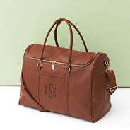 brown weekend travel bag on green background