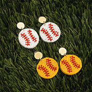 duo softball earrings and baseball earrings on grass