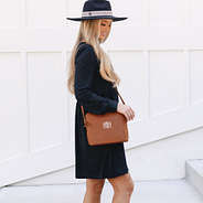girl with brown monogrammed crossbody bag over shoulder
