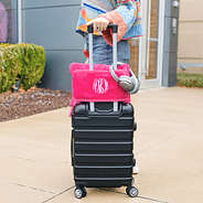 monogrammed hot pink travel blanket pillow around suitcase