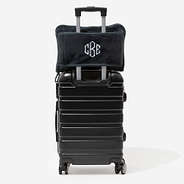 monogrammed travel blanket pillow in charcoal on suitcase