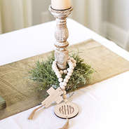 monogrammed wooden cross garland around candle on table