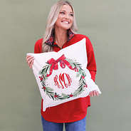 girl holding monogrammed holiday wreath pillow