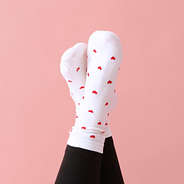 heart socks on crossed ankles on front of pink paper