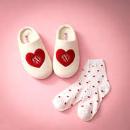 heart socks with monogrammed slippers on pink paper