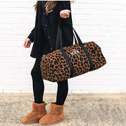 monogrammed sherpa fuzzy duffel bag in hickory leopard on wrist