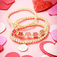 heart bracelet set scattered with hearts on pink paper
