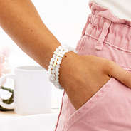 stretchy cross bracelet on wrist with hand in pocket