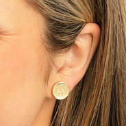gold teacher earring set in ear
