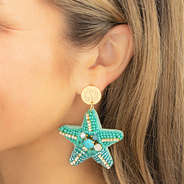 blue starfish earrings in ear