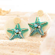 blue starfish earrings on seashells