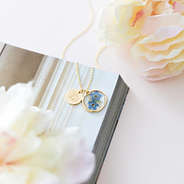 gold forget me not necklace with flowers and magazine