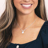 girl wearing silver monogrammed pearl necklace